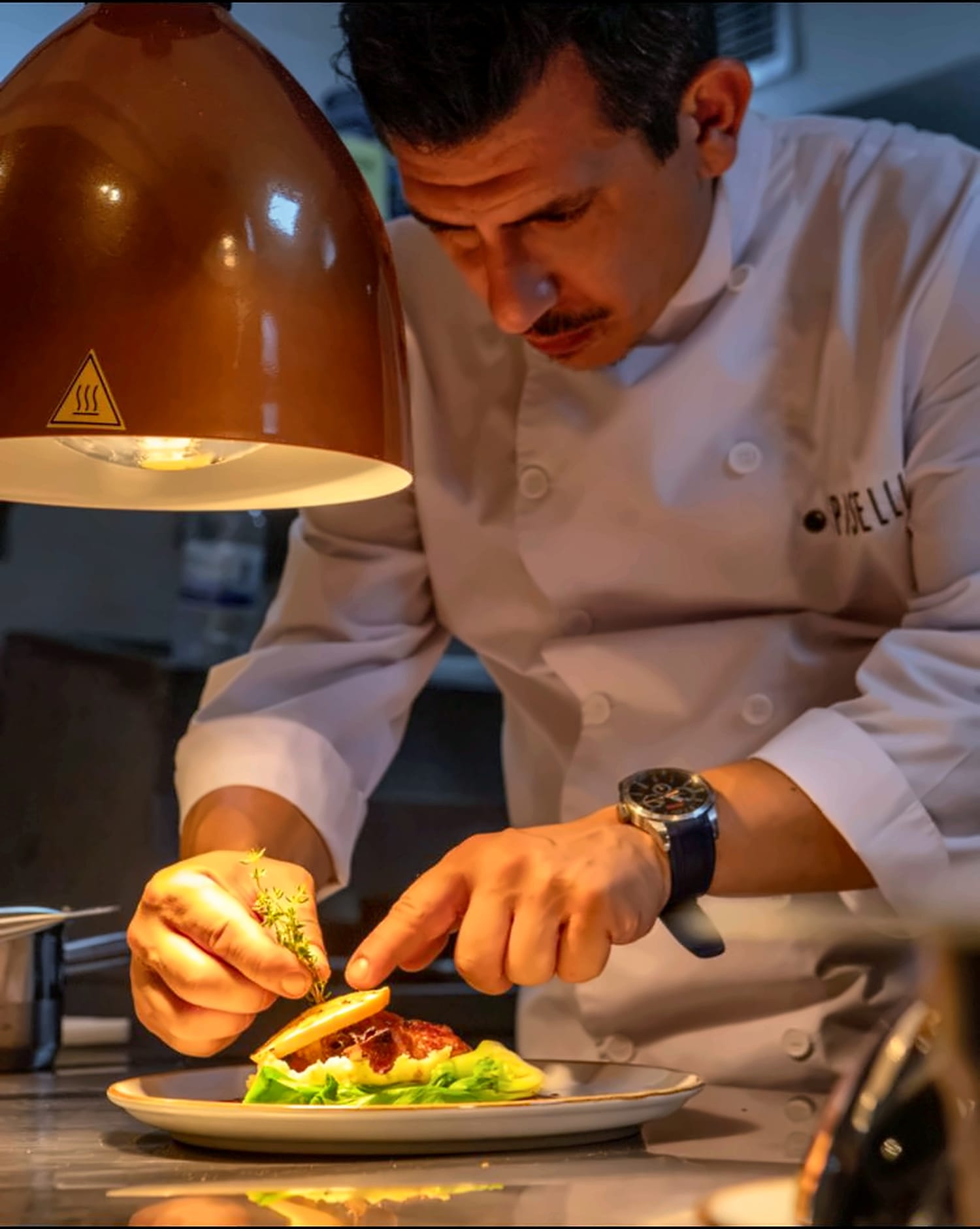 Chef Ufuk Ozan plating under the heat lamp
